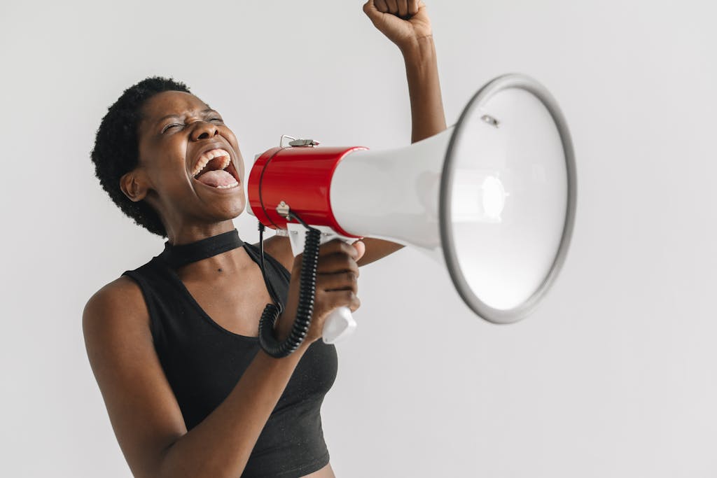 A passionate woman shouting into a megaphone, expressing empowerment and activism.