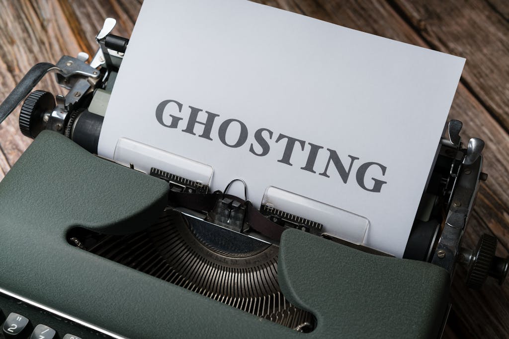 Vintage typewriter displaying the word 'ghosting' on a paper sheet symbolizing communication issues.